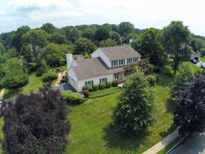 Aerial drone view of a Hamilton NJ corner lot home with large yard and surrounding suburban neighborhood