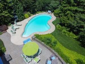 Backyard patio and inground pool at a home in Hamilton Township NJ with seating and landscaping