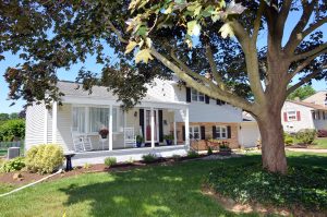 Front exterior of Hamilton NJ home framed by trees and landscaping