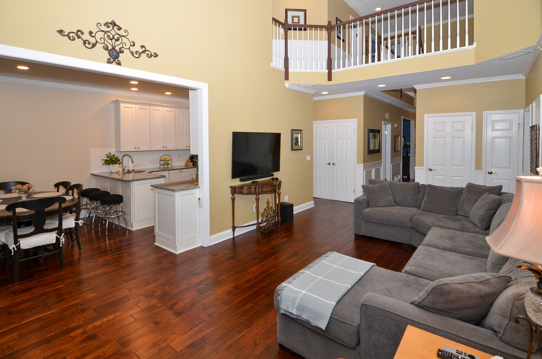 Open concept living room in Hamilton Township NJ with high ceilings, hardwood floors, and natural flow into kitchen