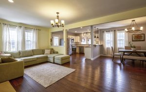 Open floor plan in Mercer County NJ home showing living room, dining area, and kitchen with hardwood floors