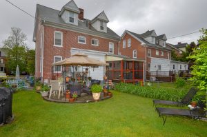 Backyard patio area in Roebling NJ home with outdoor seating and surrounding brick homes