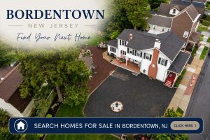 Clickable image linking to homes for sale in Bordentown NJ featuring a drone view of a residential neighborhood with suburban homes and mature trees