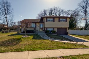 Front exterior of a split-level home in Bordentown Township NJ with average curb appeal and simple landscaping