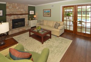 Family room in a Hamilton Township NJ home with fireplace, hardwood floors, and glass doors leading to outdoor living space