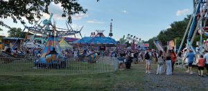 Families enjoying a community carnival during a summer evening celebration in New Jersey