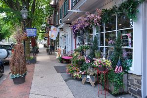 Flower displays, American flags, and storefront details along Farnsworth Avenue in Bordentown City NJ