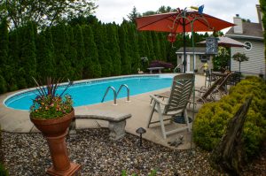 Private backyard pool and patio area surrounded by mature landscaping in Hamilton New Jersey