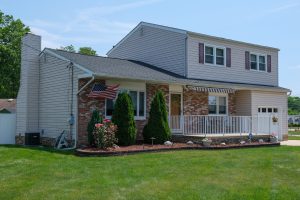 Hamilton Township NJ home displaying an American flag outside during the summer season
