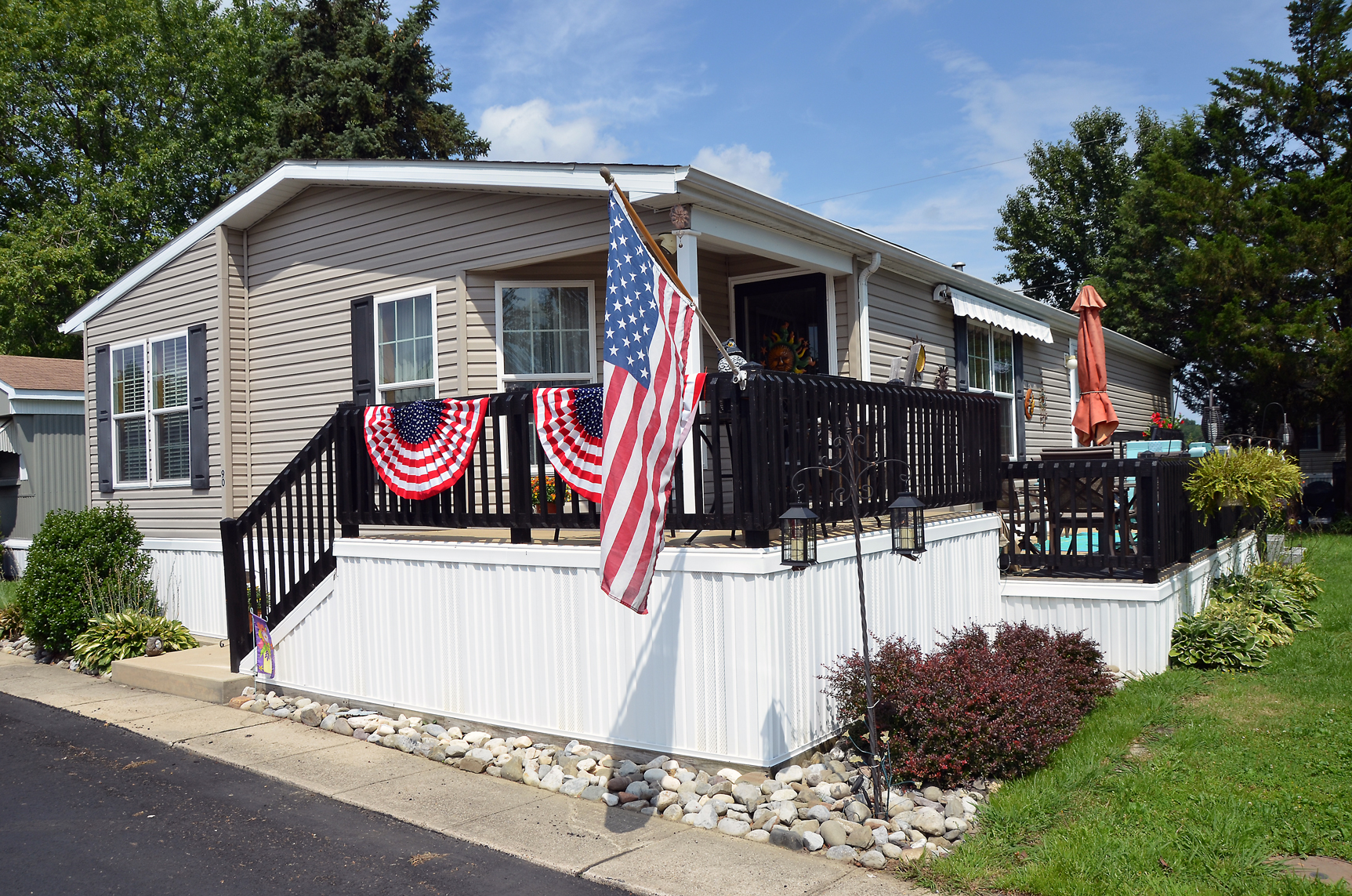 Patriotic front porch display at a New Jersey home decorated with American flags and summer seasonal decorations