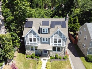 Aerial view of Trenton NJ home with solar panels, and wooded back area