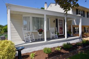 Covered front porch with rocking chairs and seating area at a Hamilton NJ home
