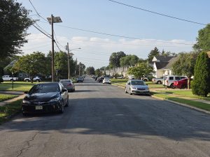 Quiet residential street in Hamilton Township NJ showing sidewalks, front lawns, and a variety of single-family homes.