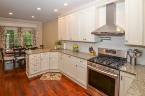 Open concept kitchen and dining area with hardwood floors, center island, and abundant natural light