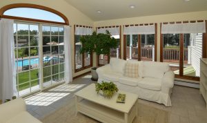Bright sunroom in a Hamilton Township NJ home featuring large windows, abundant natural light, and views of the backyard and pool.
