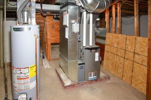 Clean basement mechanical area with furnace and water heater representing home systems that may be addressed following a home inspection.