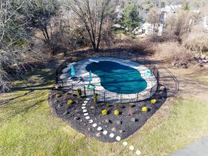 Aerial view of a covered inground swimming pool in the backyard of a Robbinsville NJ home during the off-season.