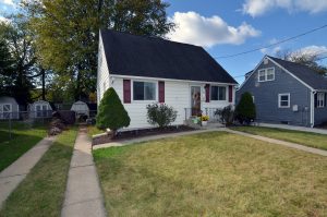 Cape Cod home with front lawn in an established residential neighborhood in Hamilton Township NJ.