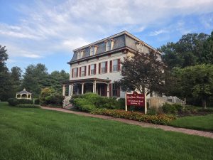 Historic Grafton House in Hamilton Township NJ with landscaped grounds, mature trees, front porch, and gazebo.