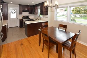 Updated kitchen and dining area in a Hamilton NJ split-level home with dark cabinetry, stainless steel appliances, hardwood floors, and bright finishes.