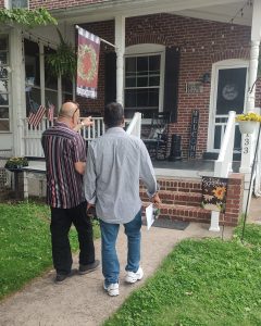 Real estate agent and home buyer walking toward the front porch of a brick home during a showing in Roebling NJ.