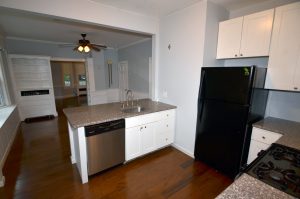 Updated kitchen in a Trenton NJ home opening into adjoining dining and living areas with hardwood floors and different interior finishes.
