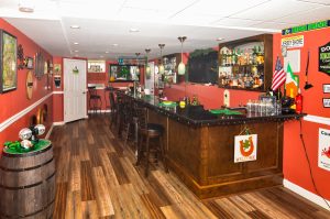 Custom pub in the finished basement of a Hamilton Township NJ colonial with wood bar, seating, televisions and entertainment area.