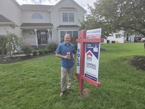 Philip Angarone standing beside a SOLD real estate sign in front of a Hamilton Township NJ colonial after the home went under contract and closed.